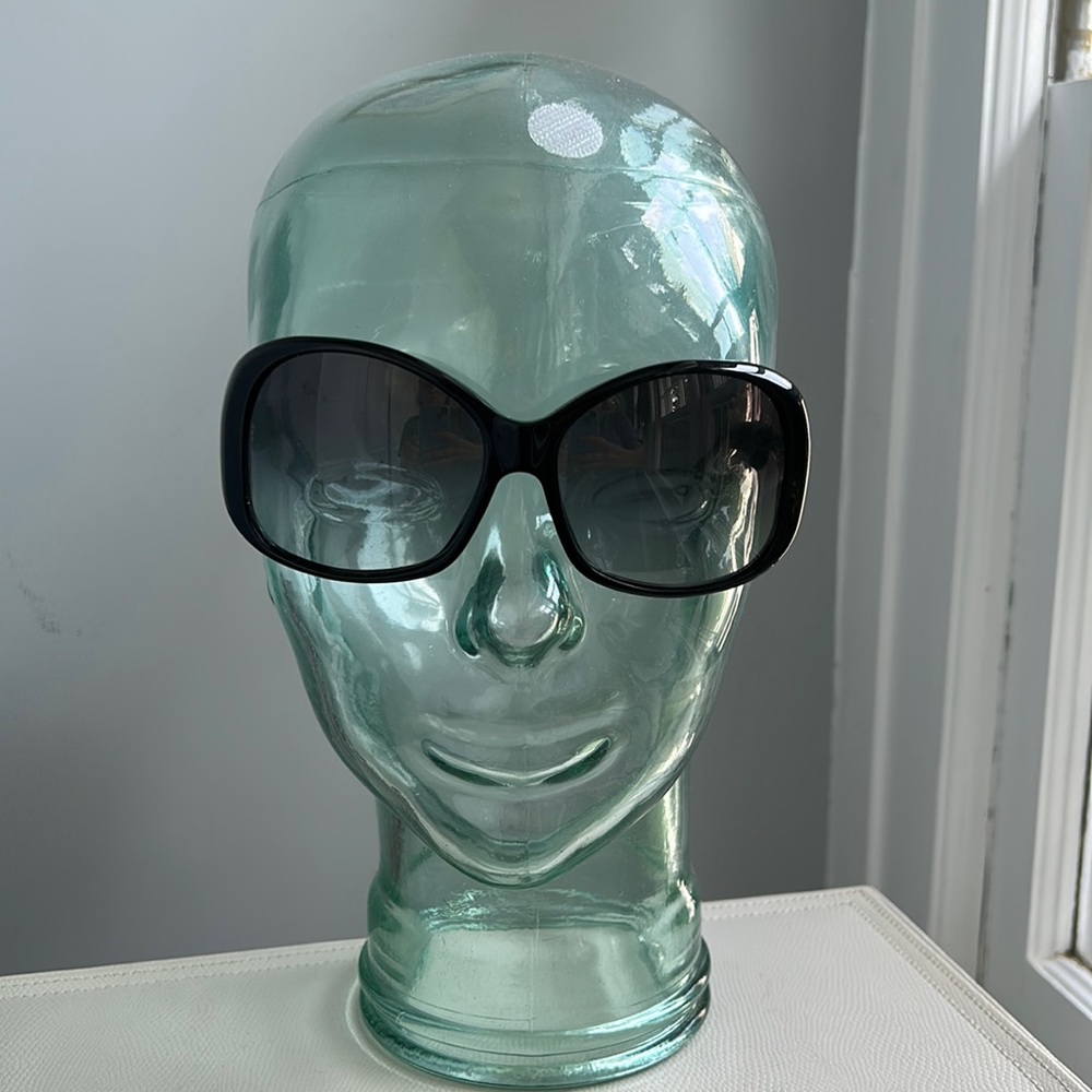 Prada sunglasses: wide shape in black. Flattering on most faces.